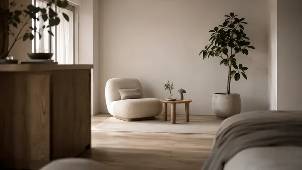 Calm corners method in a studio apartment featuring a boucle chair, oak side table, and large potted plant in natural daylight.